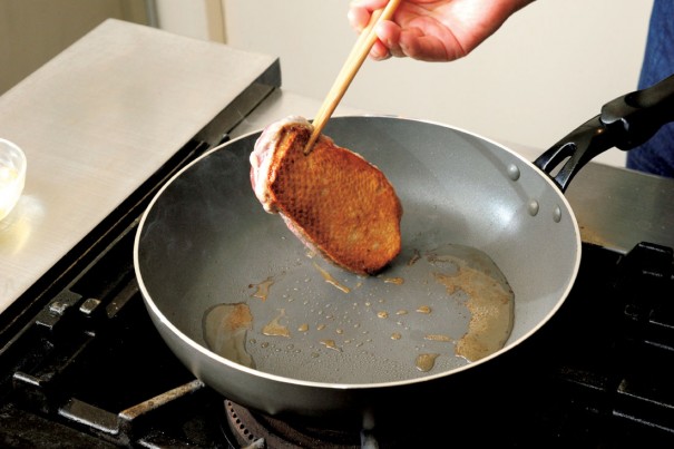 ①油を敷かずにフライパンを中火で熱したら、鴨肉の皮面から焙る。こんがりと焼き目がつくまで焙ったら、裏面も同様に焙る。