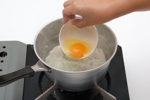 沸騰したお湯に酢を入れて、玉子を落とし入れてポーチドエッグを作る。