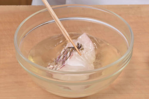 ５分ほどして切り身の表面に水分が浮いてきたら、日本酒（分量外）にくぐらせて塩を落とす。