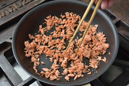 フライパンにほぐした身を入れ、醤油以外の調味料を加える。箸でかき混ぜながら弱火で炒る。
