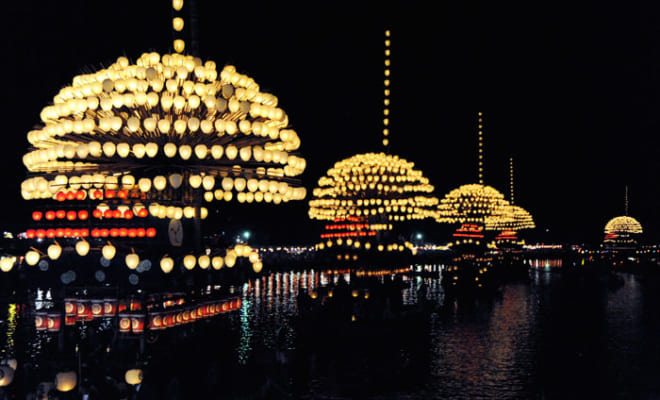 宵宮では、山型に飾られた提灯をのせた５艘のまきわら船が天王川を渡る。