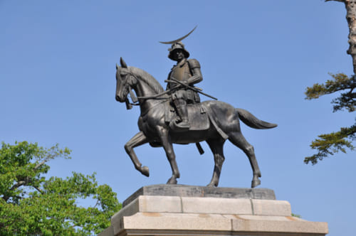 居城であった仙台城跡の青葉山公園（宮城県仙台市）にある伊達政宗像。お馴染みの三日月の前立を施した兜を冠した勇ましい騎馬像だ。