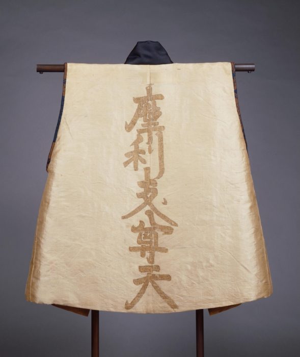 後ろ身頃には、武士の守り本尊として信仰された「摩利支尊天」の文字を籠文字で表現。その文字の内部には、護身を願う経文が細かく書き込まれています。 出典：ColBase（https://colbase.nich.go.jp/）